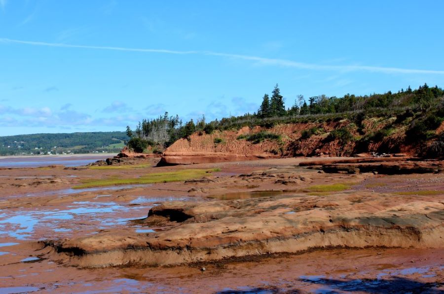 A gorgeous picture of the red cliffs exposed at low tide at Thomas Cove along the Bay of Fundy